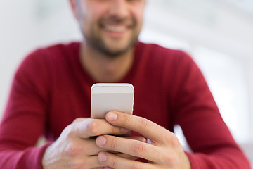 Image showing young man using a mobile phone  at home