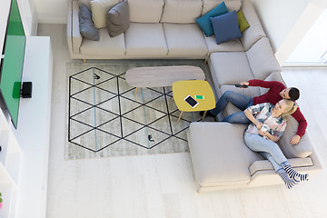 Image showing Young couple on the sofa watching television