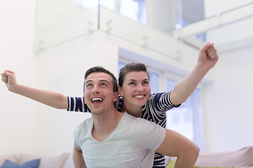 Image showing handsome man piggybacking his girlfriend