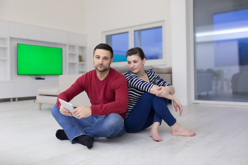 Image showing Young Couple using digital tablet on the floor