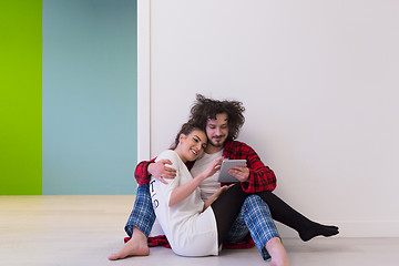 Image showing Young Couple using digital tablet on the floor