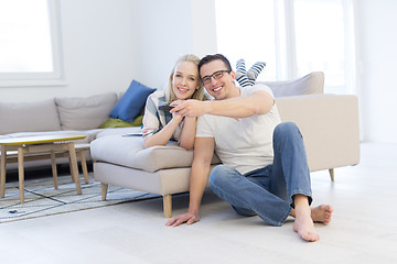 Image showing Young couple on the sofa watching television