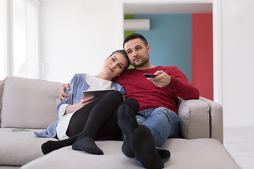 Image showing Young couple on the sofa watching television