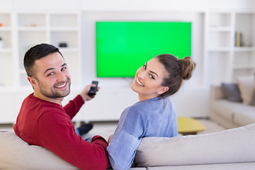 Image showing Young couple on the sofa watching television