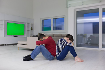 Image showing young couple sitting with back to each other on floor