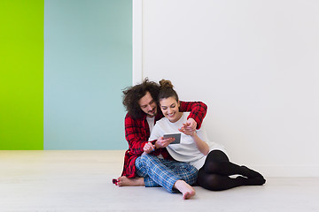 Image showing Young Couple using digital tablet on the floor