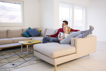 Image showing Young couple on the sofa watching television