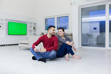 Image showing Young Couple using digital tablet on the floor