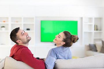 Image showing Young couple on the sofa watching television