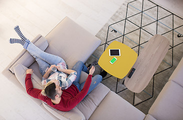 Image showing Young couple on the sofa watching television