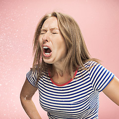 Image showing Young woman sneezing, studio portrait