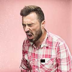 Image showing Young handsome man with beard sneezing, studio portrait