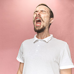 Image showing Young handsome man with beard sneezing, studio portrait