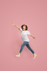 Image showing Freedom in moving. Pretty young woman jumping against pink background