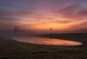 Image showing Red skies at dawn with light mist across rural farmlands