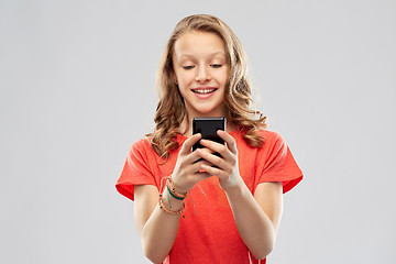 Image showing smiling teenage girl using smartphone