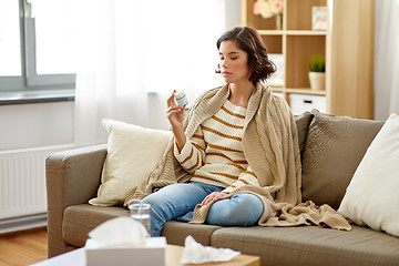 Image showing sad sick woman in blanket with drug at home