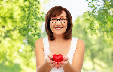 Image showing portrait of smiling senior woman holding red heart