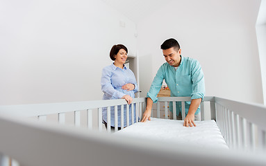 Image showing family couple arranging baby bed with mattress