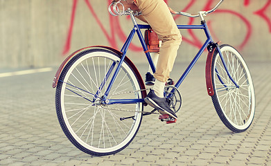 Image showing close up of hipster man riding fixed gear bike