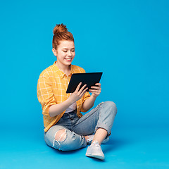 Image showing red haired teenage girl using tablet computer