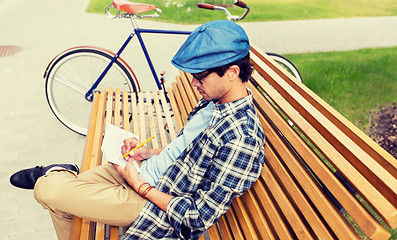 Image showing man with notebook or diary writing on city street