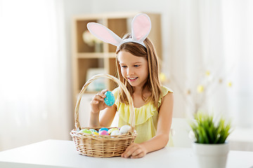 Image showing happy girl with colored easter eggs at home