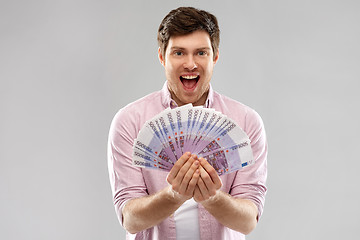 Image showing happy young man with fan of euro money