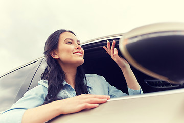 Image showing happy young woman driving in car