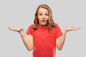 Image showing wondering teenage girl in red t-shirt shrugging