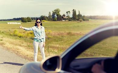 Image showing woman hitchhiking and stopping car at countryside