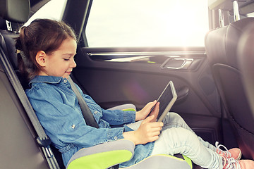 Image showing happy little girl with tablet pc driving in car