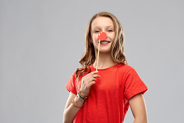 Image showing smiling teenage girl with red clown nose