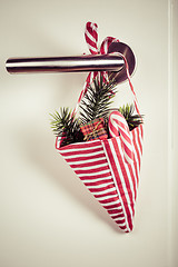 Image showing Small Christmas bag with branch and candy cane hanging on door handle