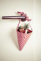 Image showing Small Christmas bag with branch and candy cane hanging on door handle