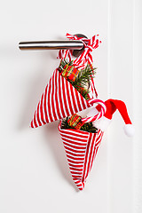 Image showing Small Christmas bag with branch and candy cane hanging on door handle