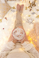 Image showing Female holds a glittering bauble among Chrismas decorations