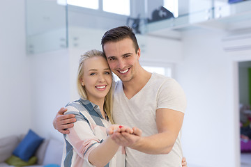 Image showing couple showing small red house in hands