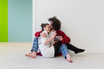 Image showing Young Couple using digital tablet on the floor