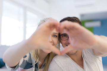 Image showing couple making heart with hands