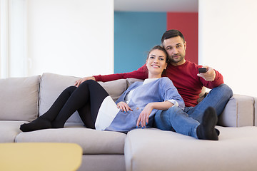 Image showing Young couple on the sofa watching television