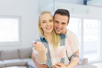 Image showing couple showing small red house in hands