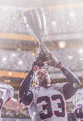 Image showing american football player with trophy celebrating victory in the 