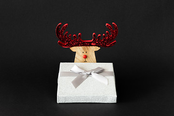 Image showing Christmas decoration reindeer with silver gift box on a black ba