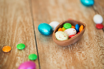 Image showing chocolate easter egg and candy drops on table