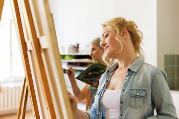 Image showing woman with easel drawing at art school studio