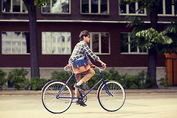 Image showing young hipster man with bag riding fixed gear bike