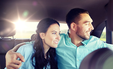 Image showing happy man and woman hugging on taxi back seat