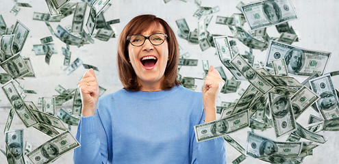 Image showing happy senior woman celebrating success over money