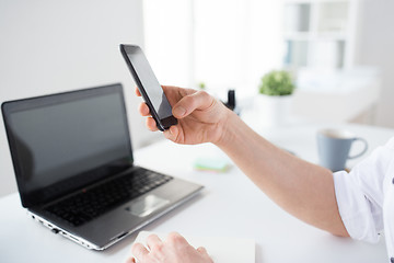 Image showing close up of businessman using smartphone at office